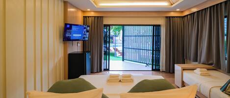 A hotel room with a bed, a desk, a TV, and a view of the outside.