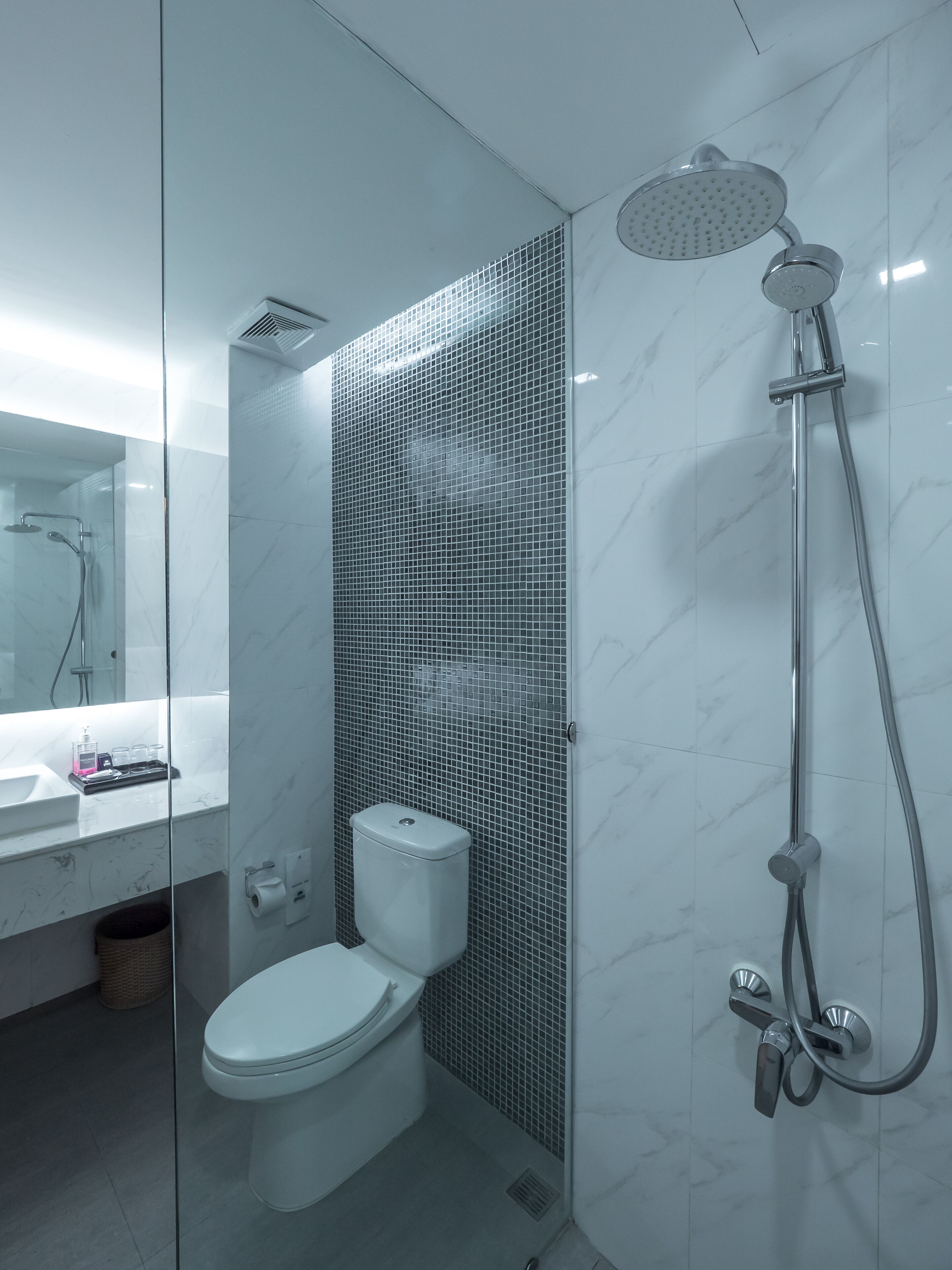 A modern bathroom with a toilet, a shower, and a sink.