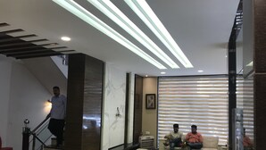 A modern interior with a staircase, a sofa, and a glass partition. - Hotel Namaskar Residency (Amritsar)