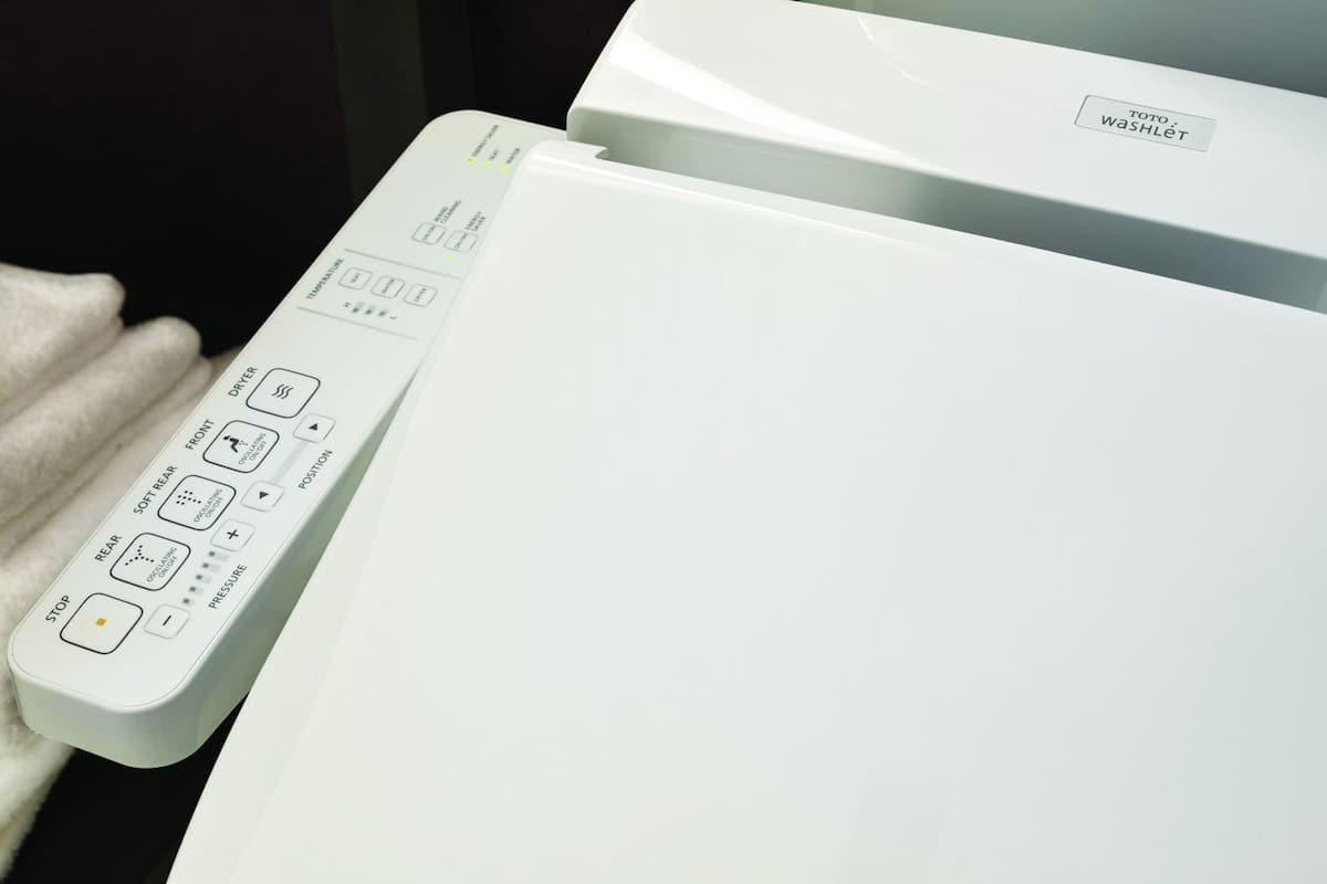 A white washing machine with a control panel featuring buttons for various functions.