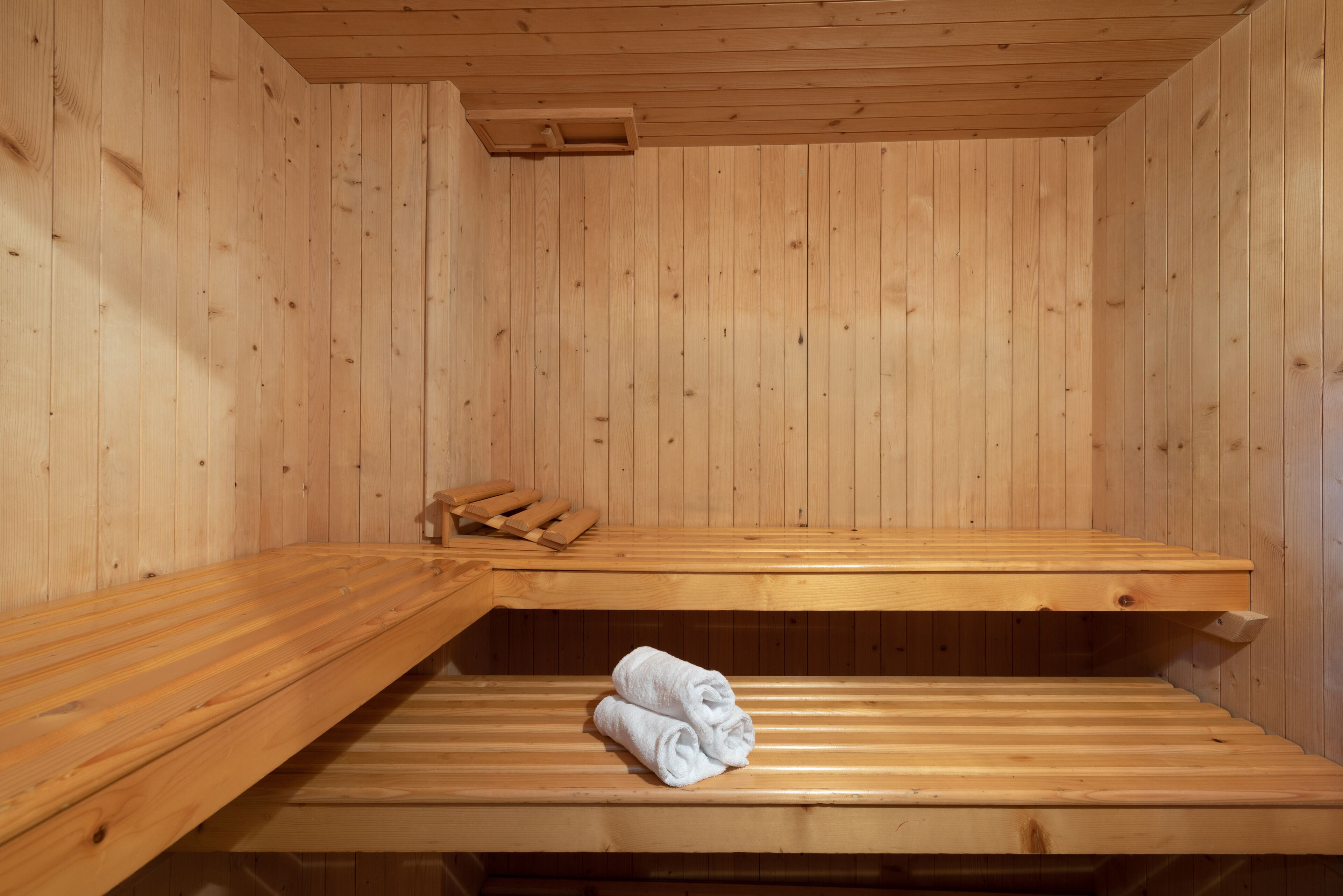 Un sauna con bancos de madera y una toalla sobre uno de ellos.