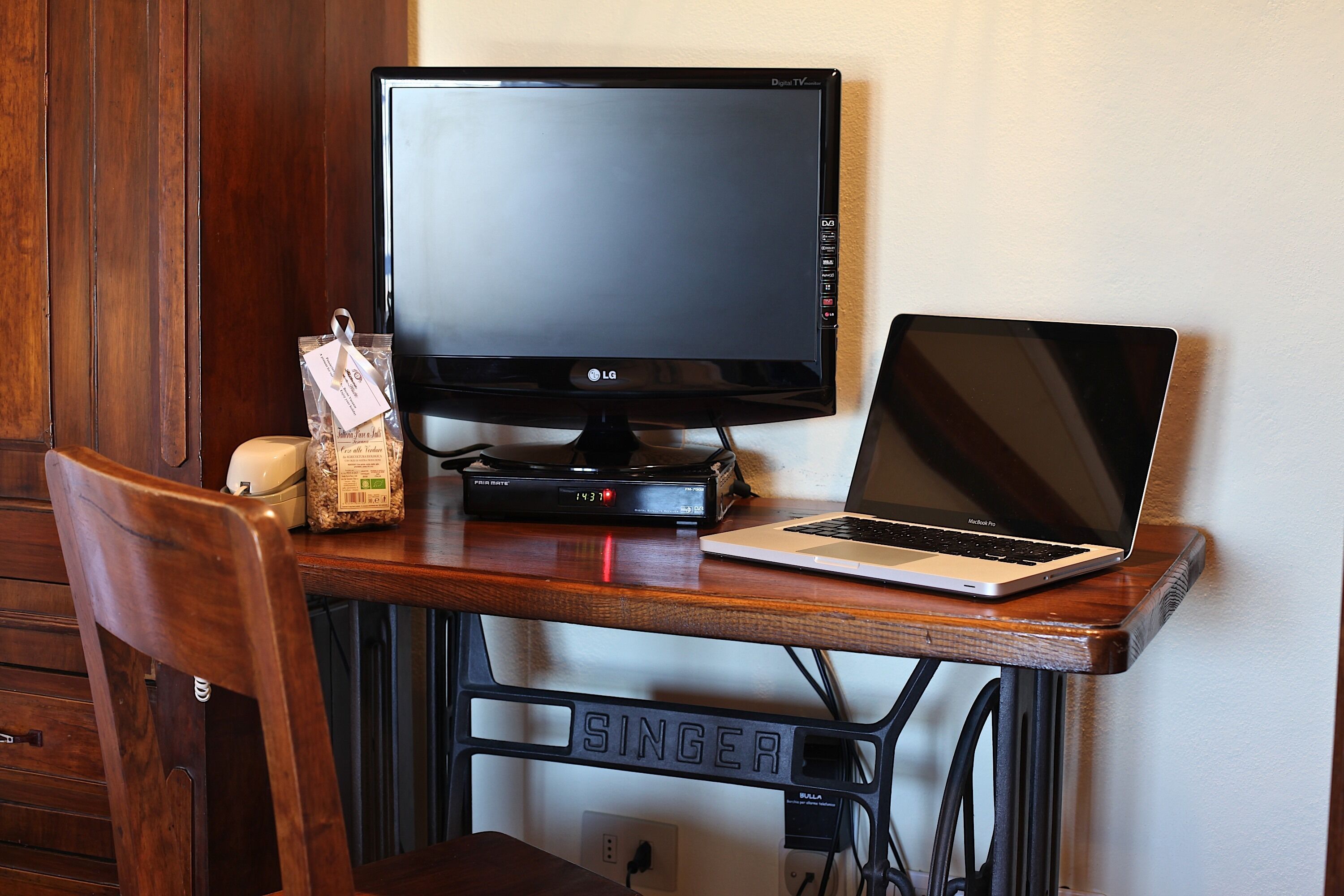 A wooden desk with a laptop and a monitor.