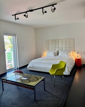A modern interior with a glass display table, red shelving units, and a window with a view of greenery. at Blanc Kara - Adults Only