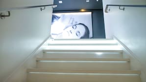 Eine Treppe mit Handlauf und einem Poster an der Wand.