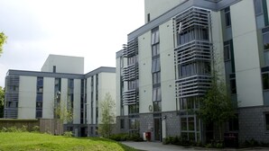 Moderni rakennus, jossa on tasakatto, suuret ikkunat ja keskeinen sisäänkäynti.