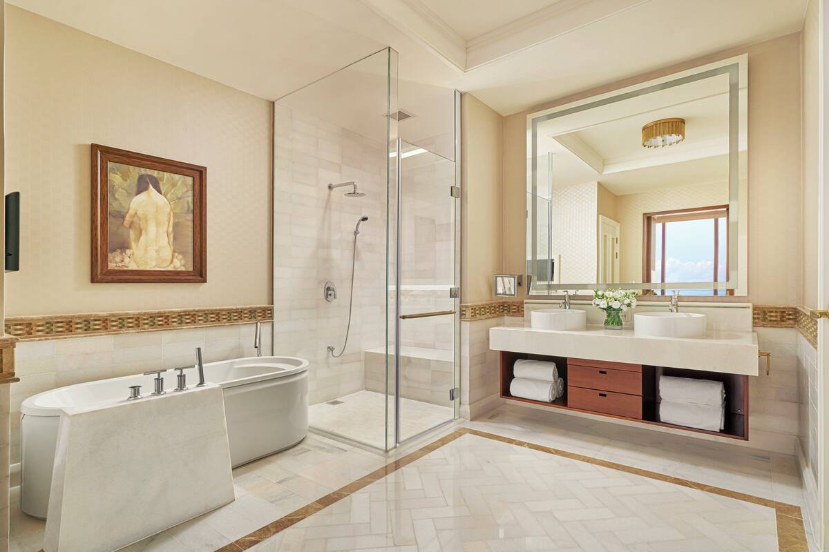 A modern bathroom with a glass-enclosed shower, a double sink vanity, and a large mirror.