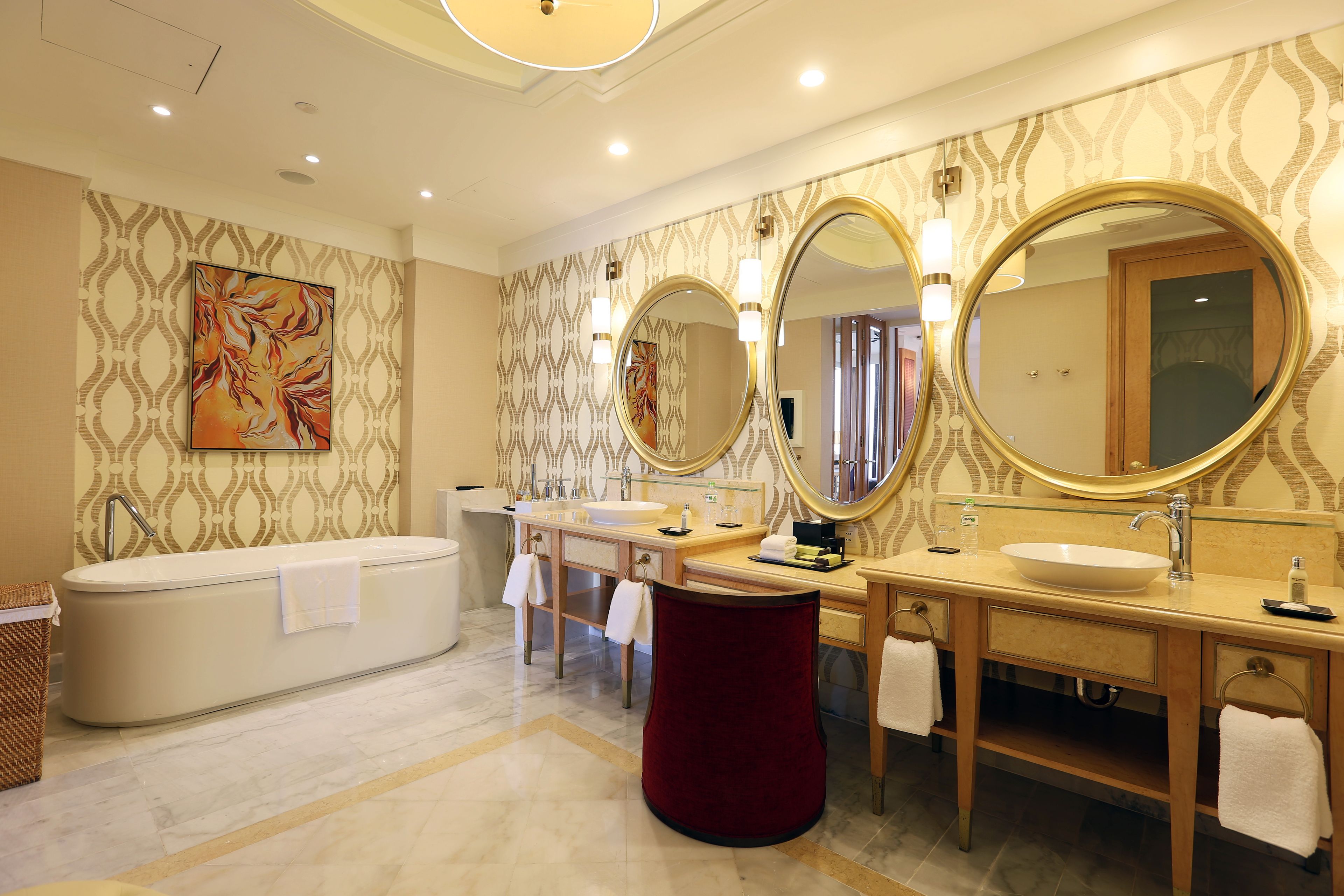 A modern bathroom with a bathtub, two sinks, and large mirrors.
