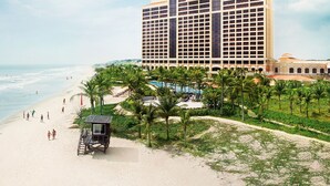 A beach resort with a large hotel, a swimming pool, and palm trees. - InterContinental Grand Ho Tram by IHG (Ho Chi Minh City)