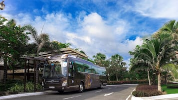 A bus with "The Grand" branding parked at a bus stop.