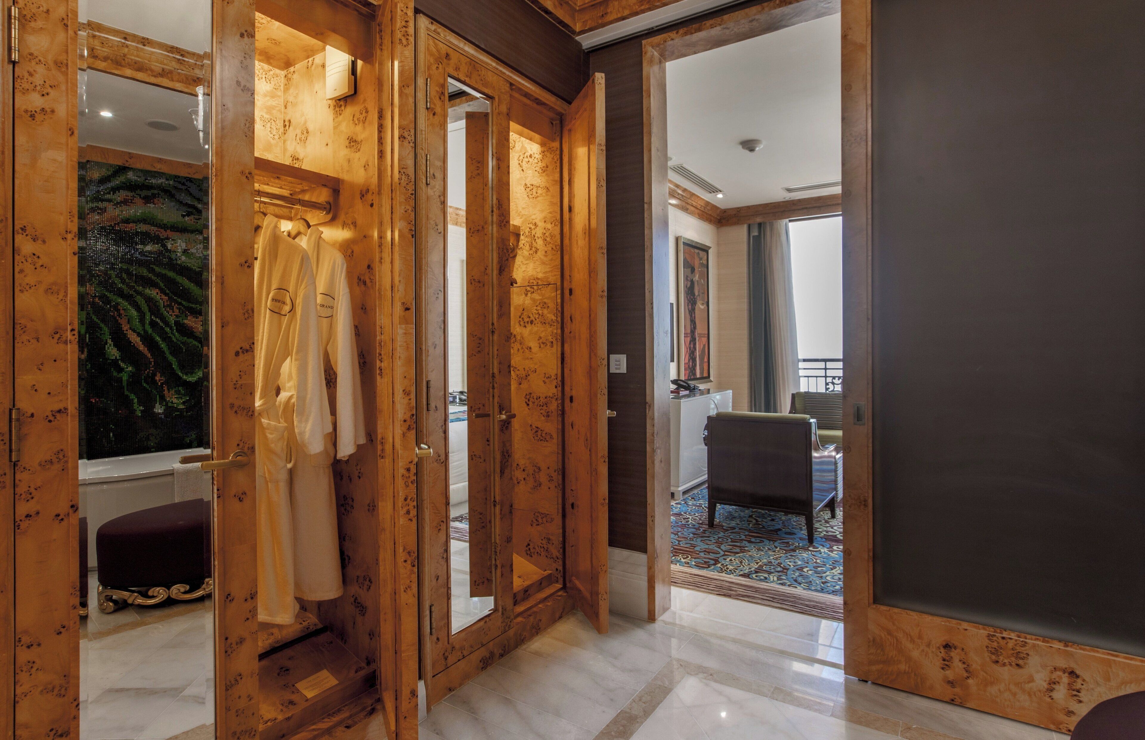 Un interior de madera con un espejo grande, un banco y vistas a un balcón.