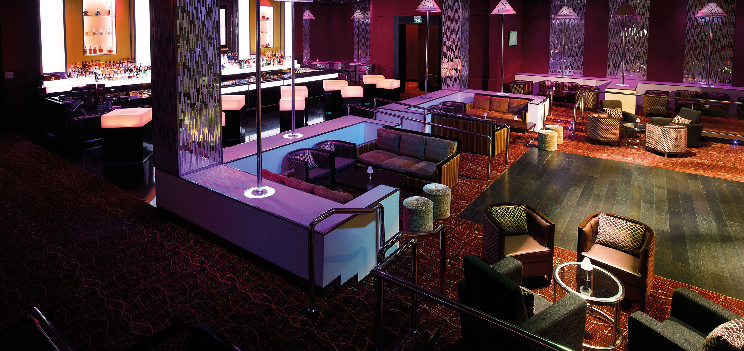 A modern bar area with seating and a pool table.