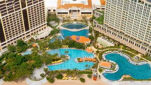 An aerial view of a resort with multiple swimming pools, a beach, and high-rise buildings. - InterContinental Grand Ho Tram by IHG (Ho Chi Minh City)