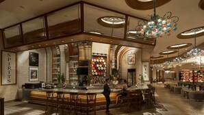 A bar area with a counter, stools, and a large chandelier. There are shelves with bottles and a sign that says "SPIRITS". - InterContinental Grand Ho Tram by IHG (Ho Chi Minh City)
