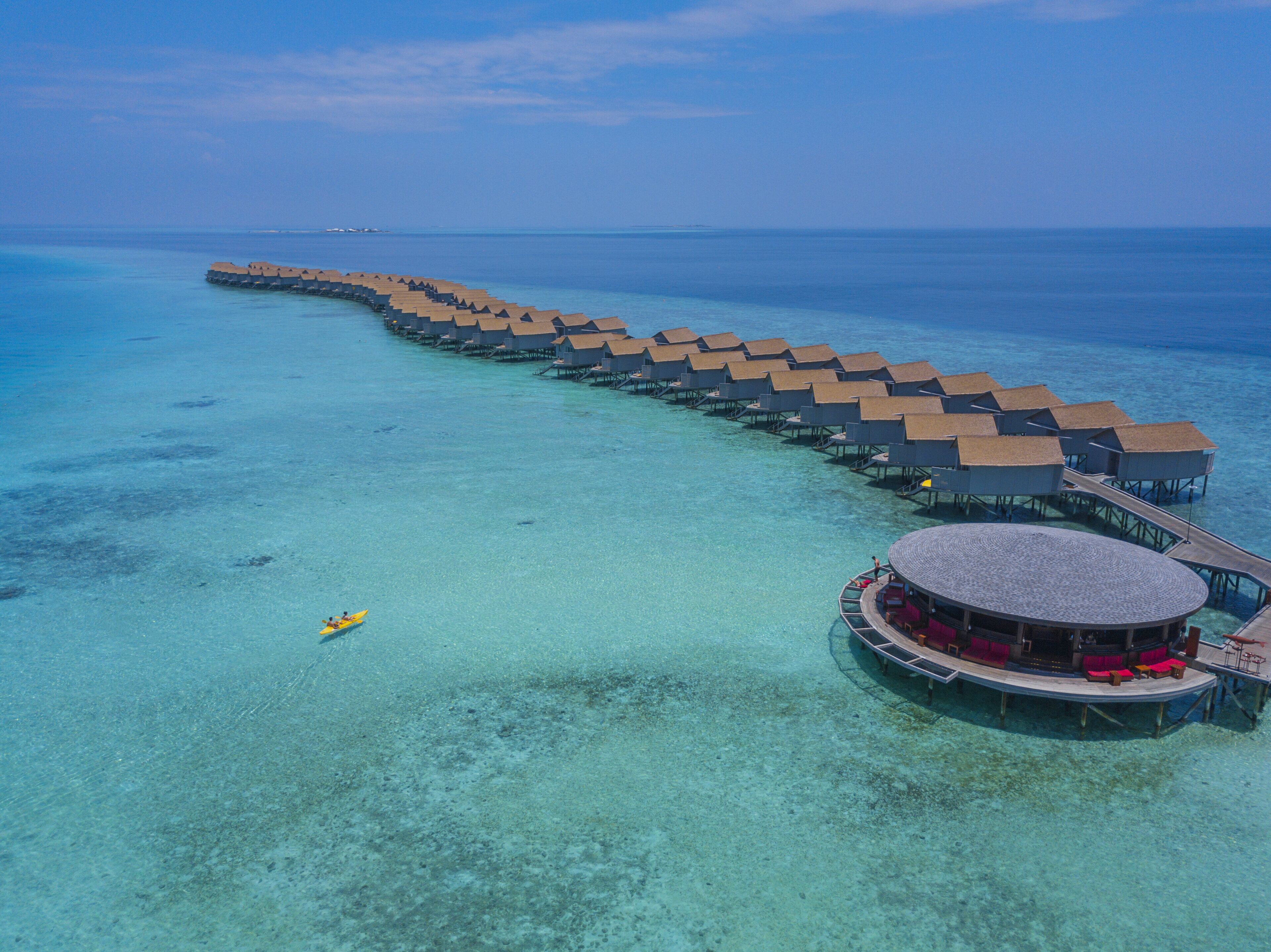 An overwater bungalows with a circular building connected by walkways.