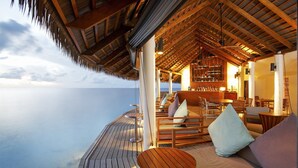 A wooden deck with outdoor seating and a bar area, overlooking the sea. - Centara Ras Fushi Resort & Spa Maldives (Giravaru)