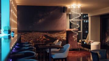 A modern interior with a bar area, seating, and a large wall mural.