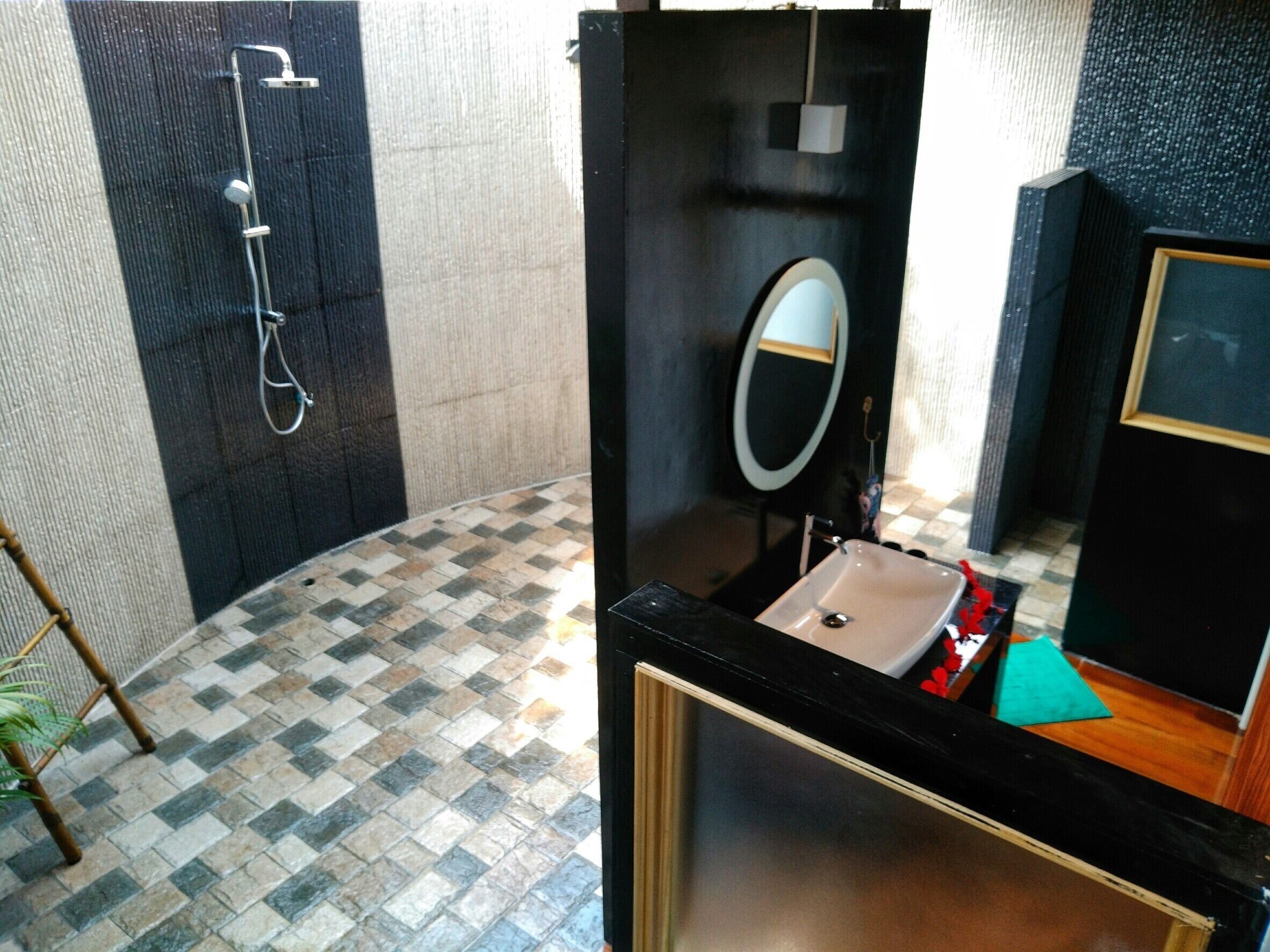 A bathroom with a shower, a sink, and a mirror.