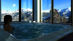 Una persona en un jacuzzi con vista a la montaña.