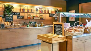 Un comptoir de boulangerie où l’on trouve des pots de confitures, du pain et des pâtisseries.