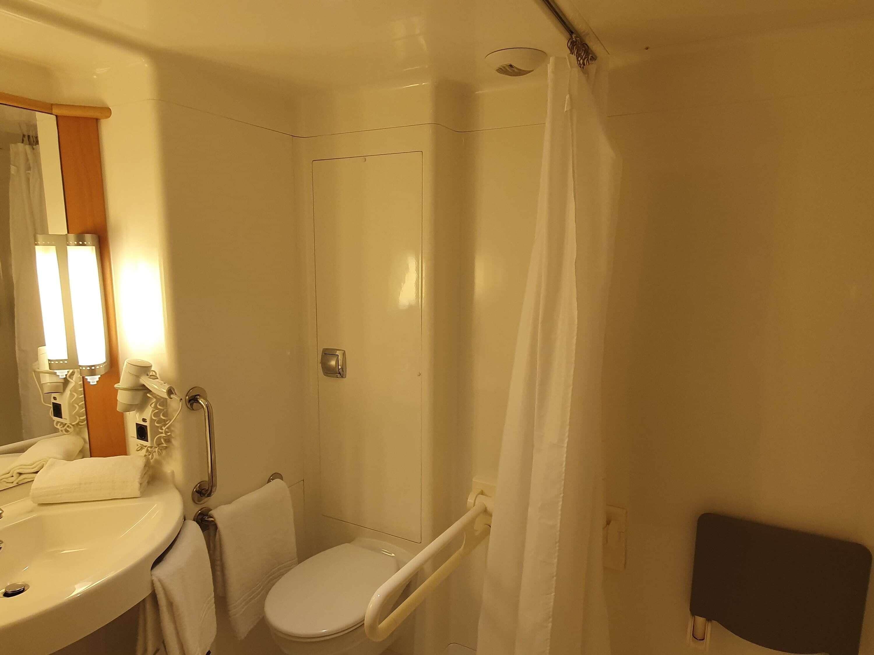Une salle de bain équipée d’un lavabo, de toilettes et d’un rideau de douche.