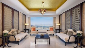 A spacious room with a large window offering a city view, two sofas, a coffee table, and decorative lamps. - Conrad Dubai (Dubai)