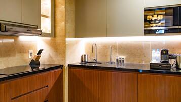 Una cocina moderna con armarios de madera, un lavamanos de acero inoxidable y un microondas integrado.