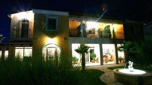 A two-story building with a well-lit entrance and a visible balcony. - Villa Vizula (Medulin)