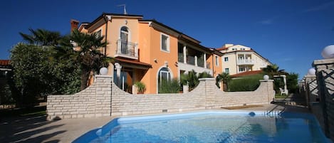Un edificio de dos pisos con piscina delantera.