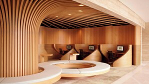 A modern reception area with a circular seating arrangement, wooden paneling, and a desk with chairs.