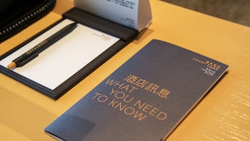 A business card and a booklet titled "What You Need to Know" on a wooden table.