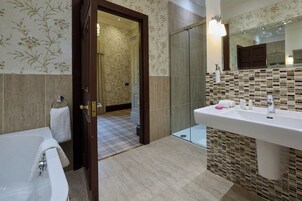 Un baño moderno con bañera, lavamanos y zona de ducha.