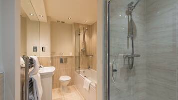 A modern bathroom with a glass-enclosed shower, a toilet, and a bathtub.