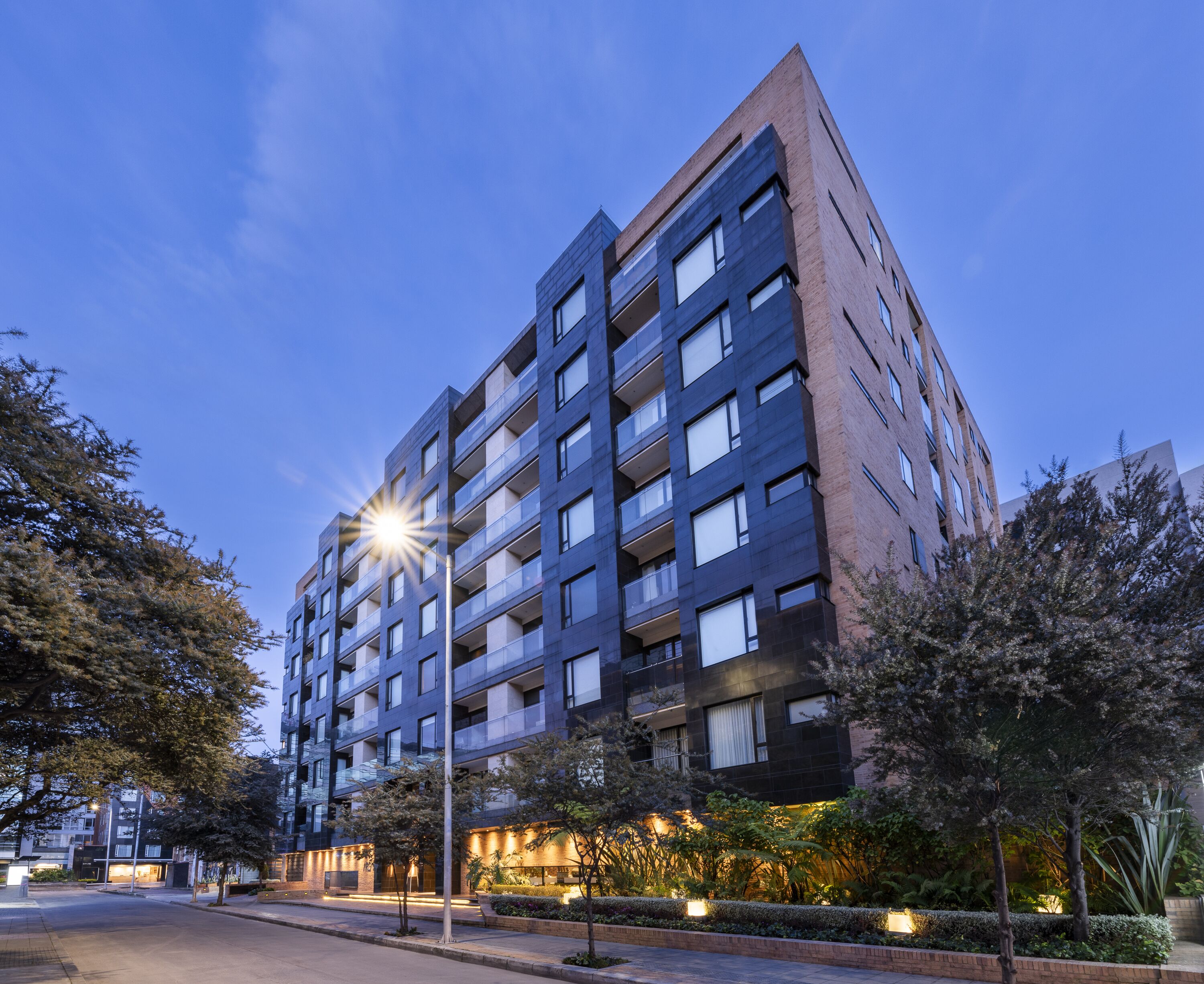 A multi-story building with a modern architectural design, featuring balconies and large windows.