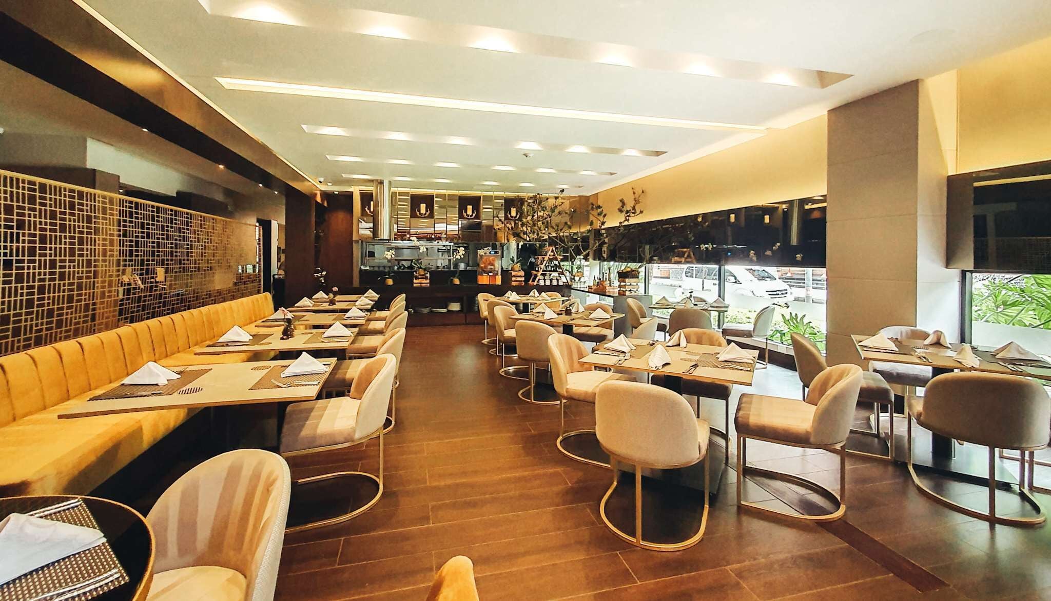 Un restaurant avec un long comptoir, des banquettes et des tables.