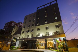Un hotel con varios pisos, amplias ventanas y una entrada bien iluminada.