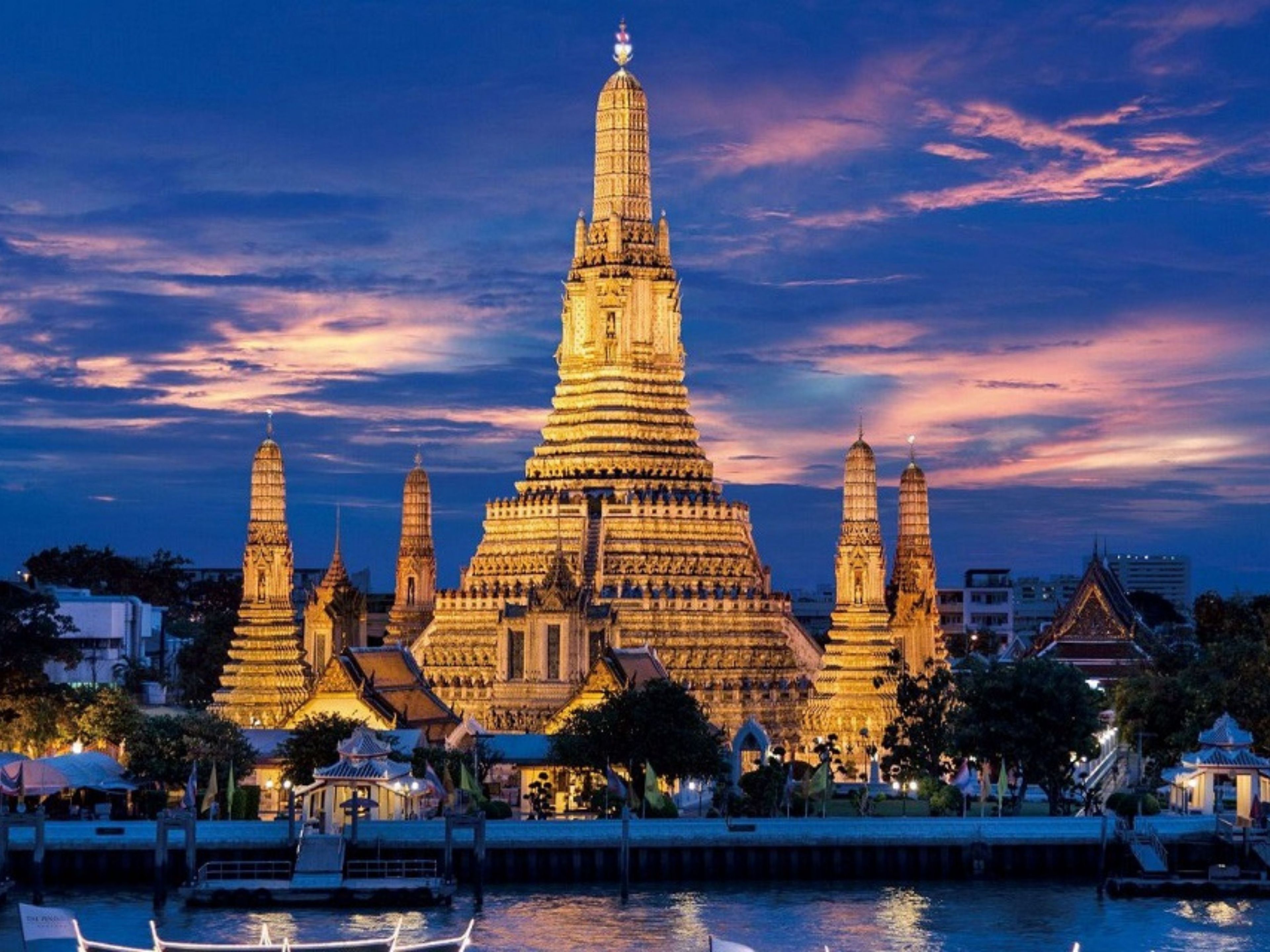 A large temple complex with multiple spires, surrounded by water and trees.