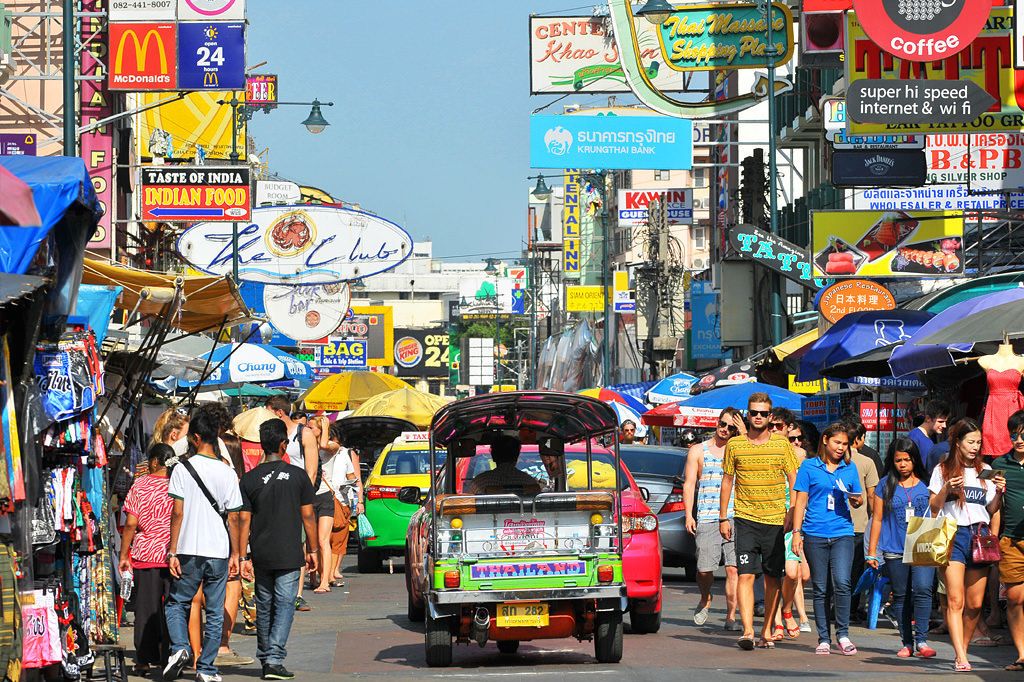 A busy street with various shops and signs, including a McDonald's and a sign for Taste of India.