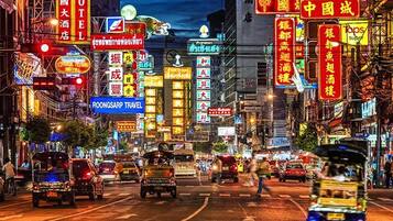 A busy street with neon signs and a hotel sign.