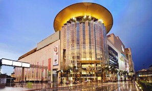 A modern building with a large glass facade and a distinctive curved roof. - Sala Rattanakosin Bangkok (Bangkok)