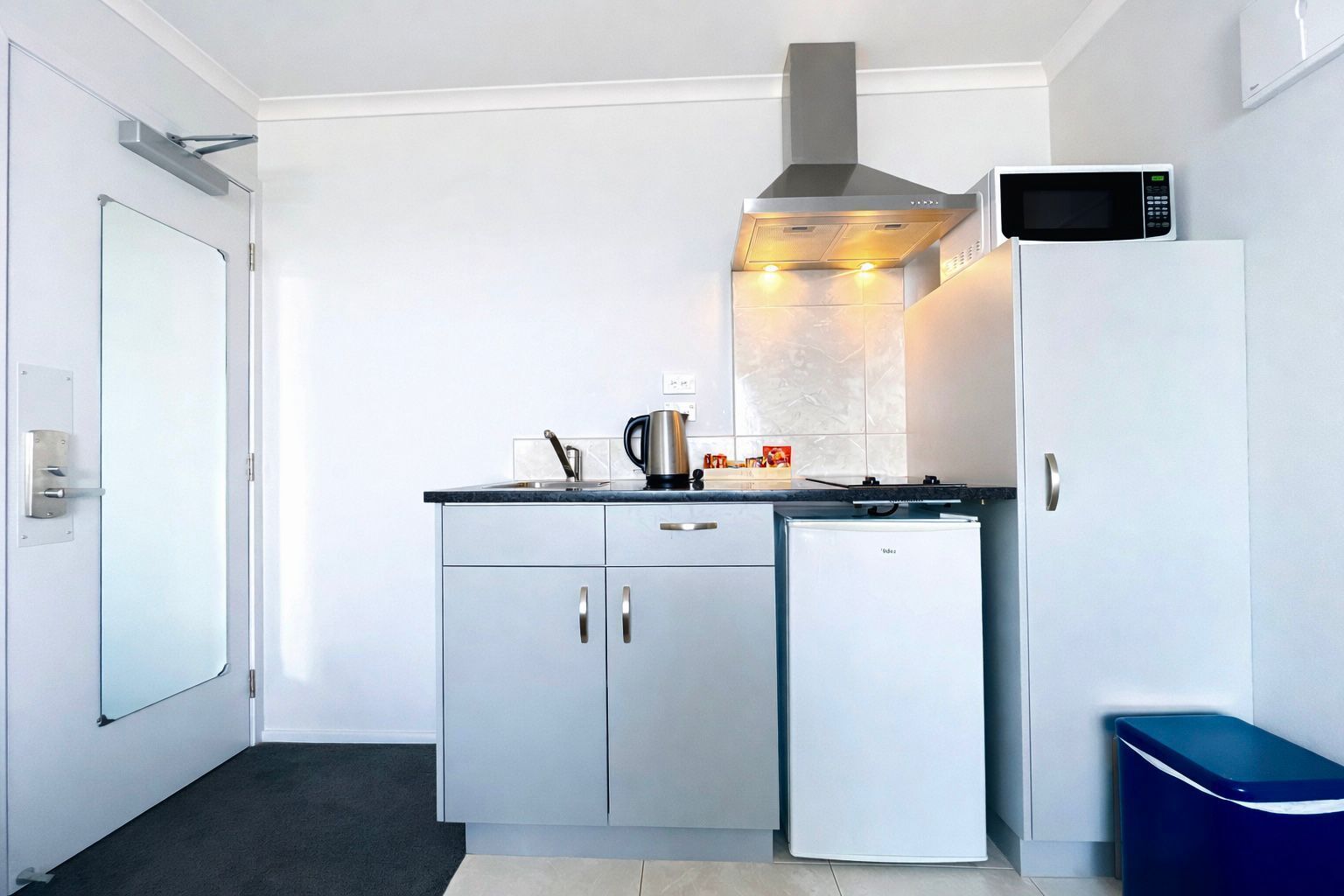 A compact kitchen with a microwave, stove, and refrigerator.