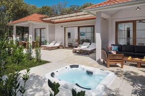 A covered outdoor area with a hot tub, lounge chairs, and a sofa. - Camping Homes Mon Perin (Bale)