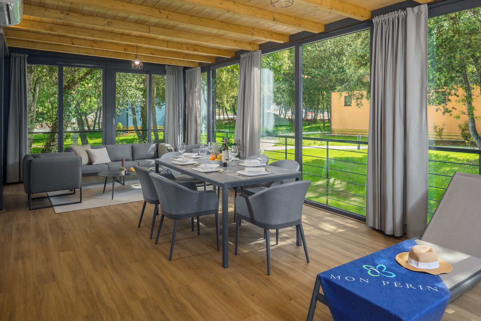 A dining area with a table set for four, a sofa, and a lounge area with a table and a hat.