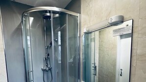 A modern bathroom with a glass-enclosed shower, a sink, and a mirror. - Eliza House (Edinburgh)