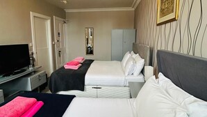 A hotel room with two beds, a TV, a desk, and a mirror. - Eliza House (Edinburgh)