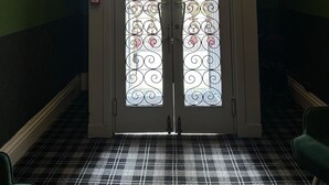 A fire exit door with a sign, a chandelier, and a checkered floor. - Eliza House (Edinburgh)