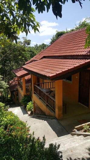 A two-story building with a red-tiled roof and a balcony.