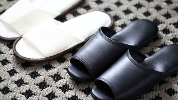 A pair of black and white slippers on a patterned rug.