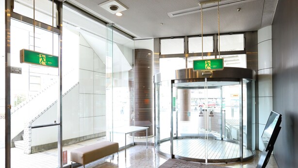 A modern lobby with a glass elevator, a bench, and a clear view of the outside. - APA Hotel Sagamihara Hashimoto Ekimae (Sagamihara)