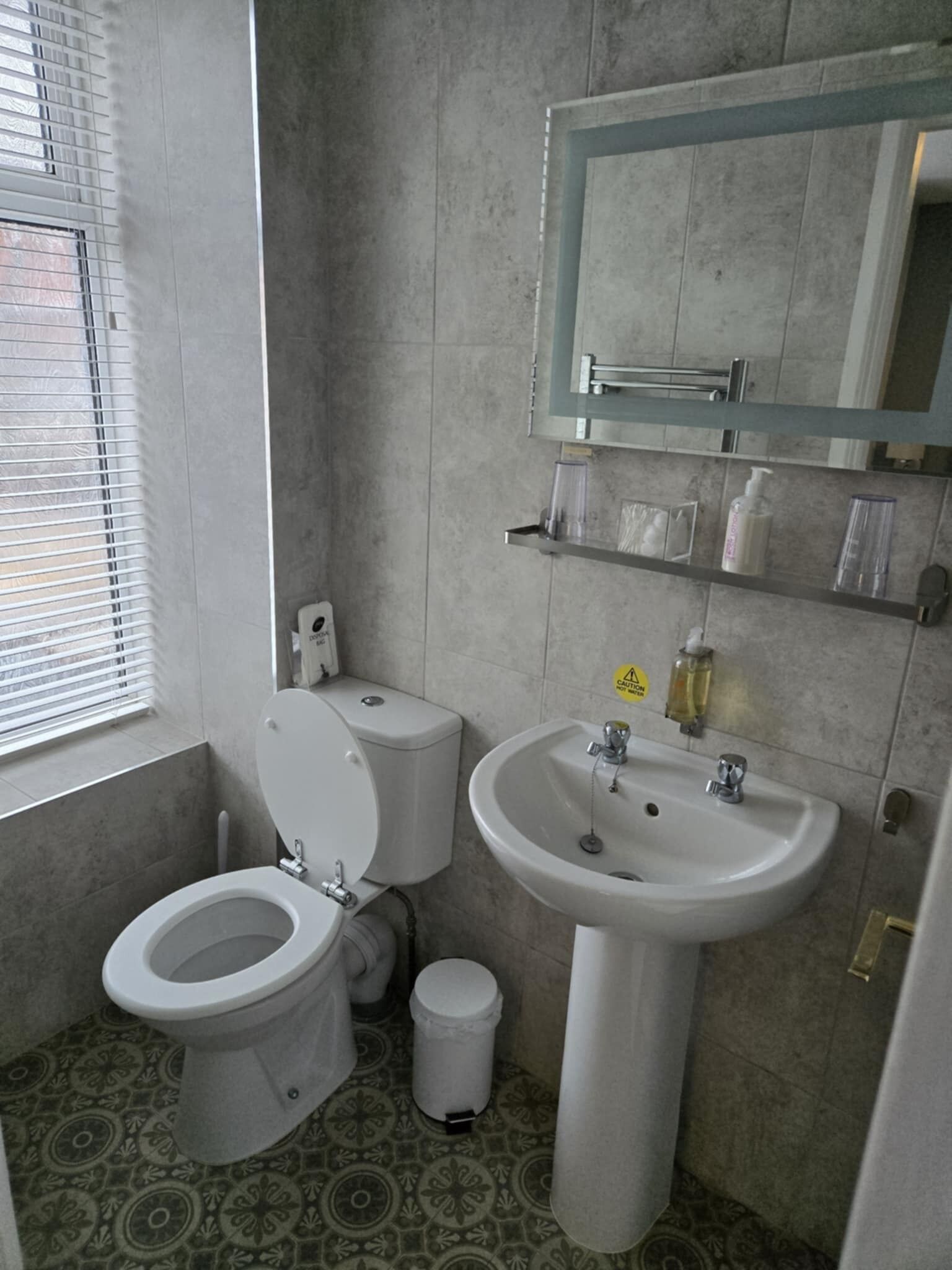 Ein Badezimmer mit Toilette, Waschbecken und Spiegel.