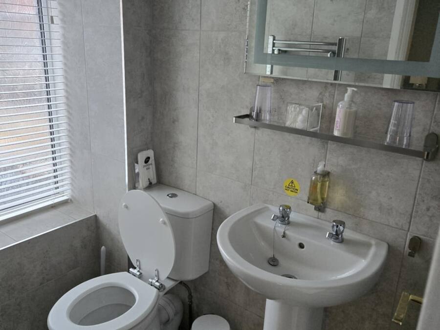 Ein Badezimmer mit Toilette, Waschbecken und Spiegel.